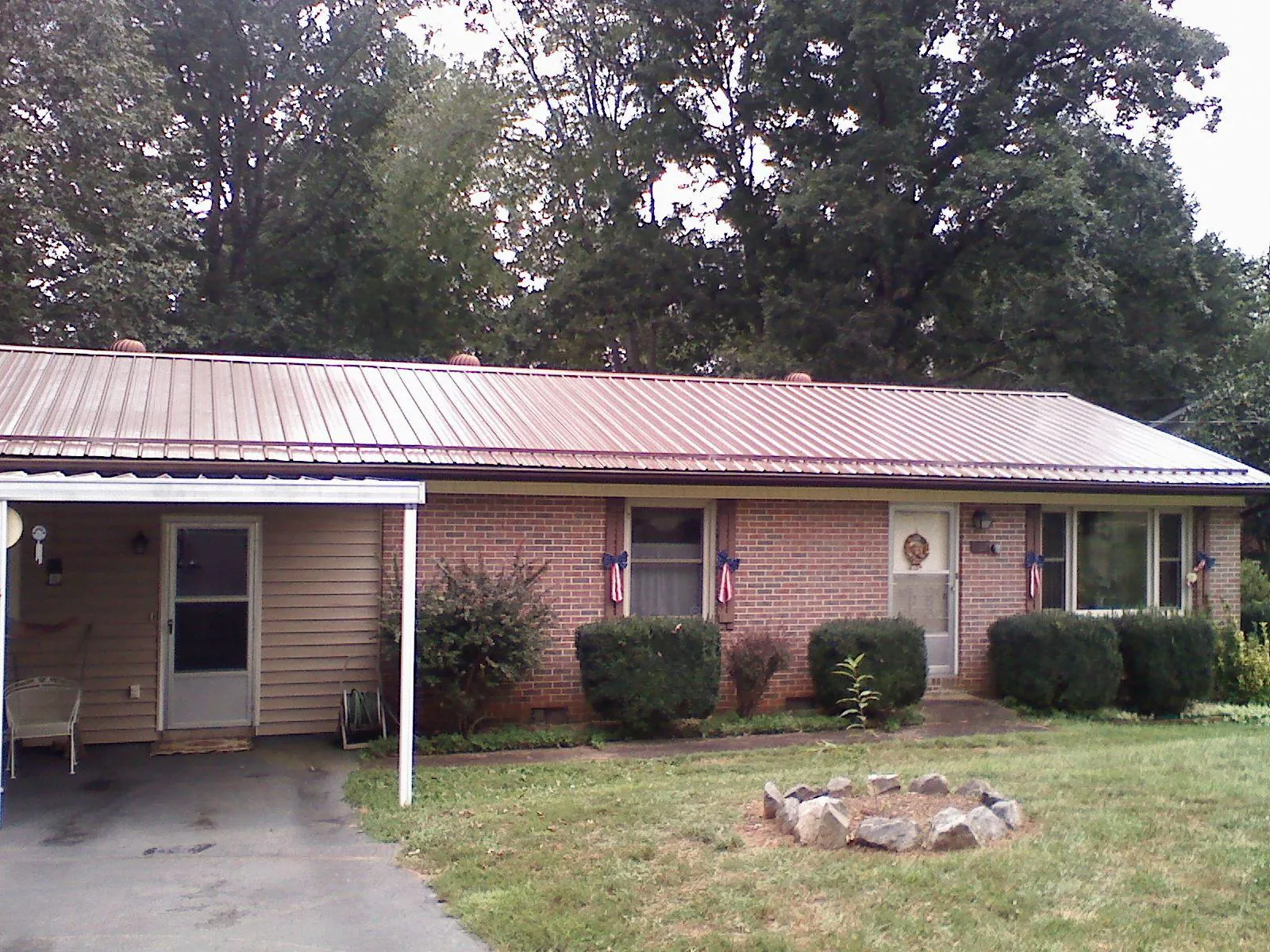 Bronze metal roof and carport on a brick ranch home — Roof Repair work by our crew in Westport